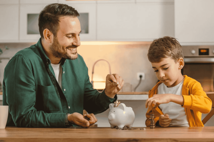 Vater und Sohn beim Sparen mit dem Sparschwein 